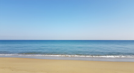 Fototapeta premium Turquoise Sea Waves Washing onto Sandy Beach Under Clear Blue Sky During Sunny Day at Coastline