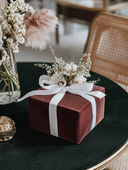 Small gift box wrapped in red and white striped paper with a white ribbon tied around it.
