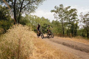 Outdoor cycling enthusiasts enjoying a scenic trail through a forested park.