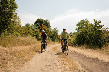 Two cyclists enjoying a pleasant bike ride along a rural trail on a sunny day