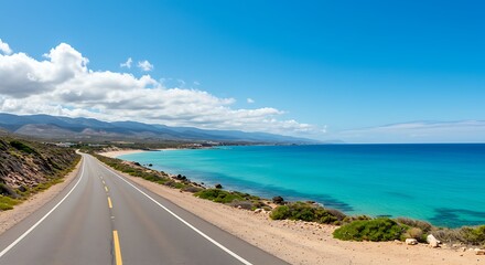Scenic coastal highway winding along turquoise ocean and distant mountains
