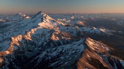 Panoramic sunset view of a majestic snow-capped mountain range, with shadows accentuating the rugged peaks and valleys