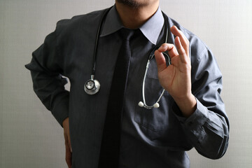 Doctor with stethoscope showing okay hand gesture in hospital concept