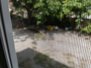 Fly screen mosquito net attached to window frame for insect protection © Emre Akkoyun