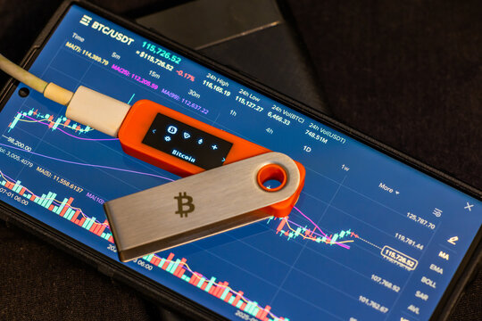 hardware Bitcoin wallet on smartphone displaying chart - Powered by Adobe