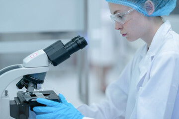 A medical researcher in a laboratory uses a pipette to transfer a liquid sample from a tray of tips. This is a key step in preparing for DNA analysis or other scientific tests.