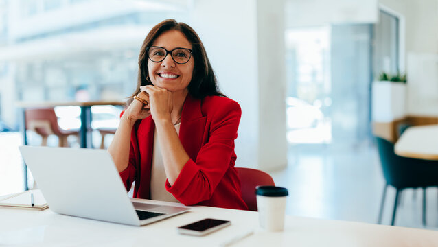 Confident businesswoman smiling while working in a bright office environment