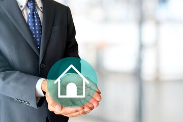 家のアイコンを持つビジネスマン