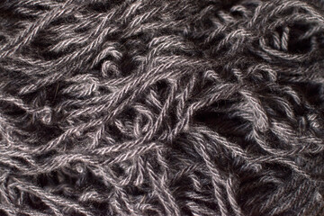 Rough fabric wool texture. Macro photo of dark wool fabric with tangled threads, ideal for textile backgrounds, fashion design, or craft themes.