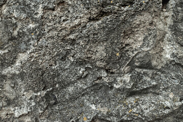 Weathered concrete wall texture. Close-up of old grey concrete surface with cracks and rough structure, urban grunge background.