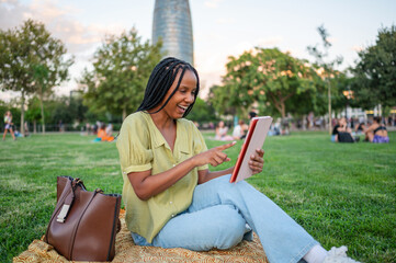 Happy freelancer woman using tablet in Barcelona, Spain