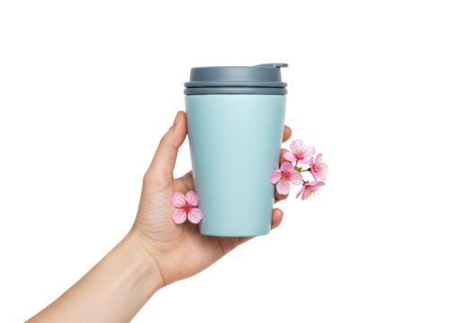 Isolated hand holding travel mug with blossoms for spring drink on the go in nature