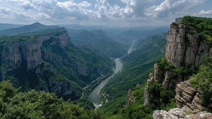 Panoramic view of a verdant river canyon nestled between towering, rocky cliffs under a partly cloudy sky