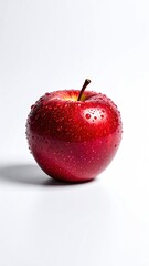 Fresh shiny red apple with water droplets isolated on a clean white background.
