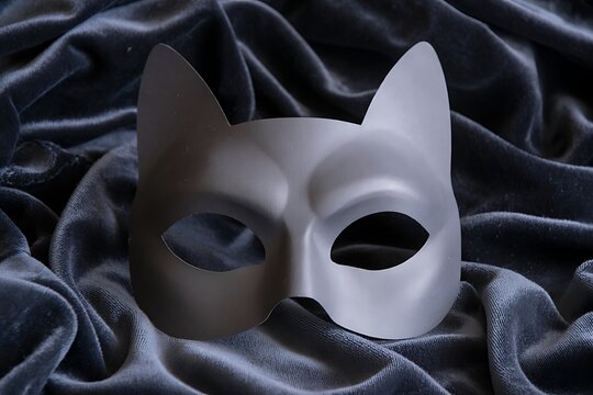 Mysterious cat mask on dark velvet fabric evokes intrigue and playful elegance for costume or masquerade events.