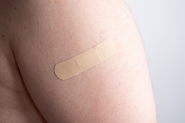 Male hand with a medical adhesive plaster close-up. Adhesive plaster on damaged skin. First aid for wounds and cuts 