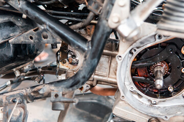 Close-up of a motorcycle engine crankcase and transmission parts exposed during repair. Showing gears, bearings, and mechanical components.