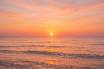 Golden sun setting over a calm ocean with warm orange and pink sky