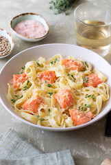Pasta fettuccine in a creamy sauce with salmon, cheese and thyme. Italian cuisine. Healthy eating.