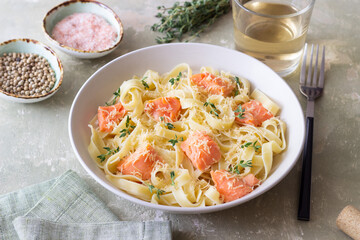 Pasta fettuccine in a creamy sauce with salmon, cheese and thyme. Italian cuisine. Healthy eating.