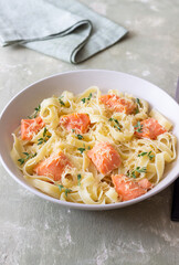 Pasta fettuccine in a creamy sauce with salmon, cheese and thyme. Italian cuisine. Healthy eating.