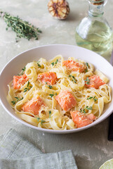 Pasta fettuccine in a creamy sauce with salmon, cheese and thyme. Italian cuisine. Healthy eating.