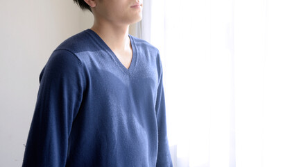 窓辺に佇む若い日本人男性