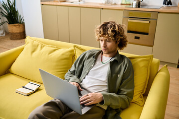 Handsome man enjoys quiet moment working on laptop in bright, cozy living space