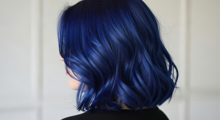 A striking rear view of a woman with beautiful hair dyed a vibrant navy blue color
