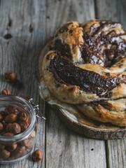 Homemade puff pastry with chocolate and hazelnuts on a rustic wooden table