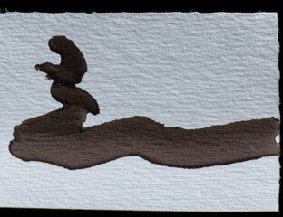 Abstract ink blot on off-white paper