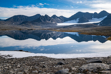Mirrored mountains on the surface of a lake in Sarek National Park - Sweden