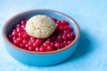 Red Currants and a Fresh Homemade Cookie in a Blue Bowl on a Blue Background