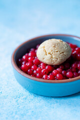 Red Currants and a Fresh Homemade Cookie in a Blue Bowl on a Blue Background