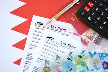 Bahraini dinar money bills and calculator with tax form on flag. Taxation and accounting concept