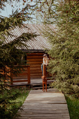 Fototapeta premium A woman is standing on a charming wooden porch along with a dog