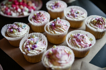 Colorful cupcakes with pink frosting and sprinkles on a table