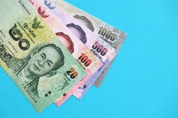 Thai baht money bills in big amount on blue. Finance and banking concept