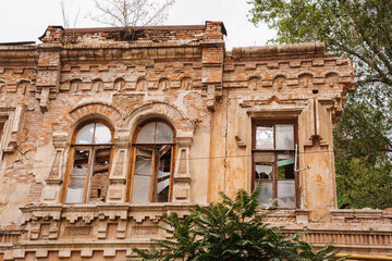 Exploring an old building with weathered architecture and broken windows
