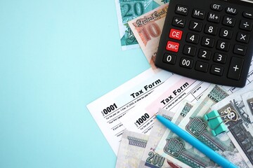 Egyptian pound money bills and calculator with tax form on blue. Taxation and accounting concept
