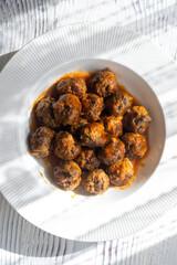 Close-Up of Spanish Albóndigas in Tomato Sauce on a White Plate

