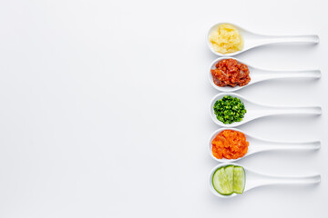 White spoons with sushi ingredients - salmon, cream cheese, isolated on a white background