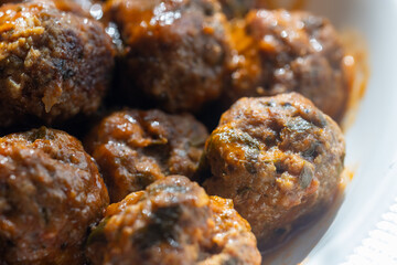 Close-Up of Spanish Albóndigas in Tomato Sauce on a White Plate
