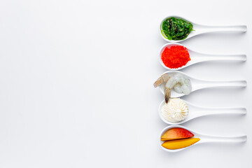 Sushi ingredients in white spoons on a white background. Shrimp, mango, cream cheese
