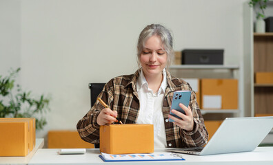 Woman start up small business owner at workplace. small business entrepreneur SME or freelance asian woman working with box at home.