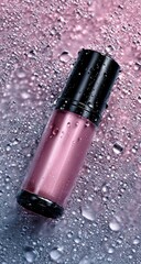 Pink cosmetic bottle on a wet surface (1)