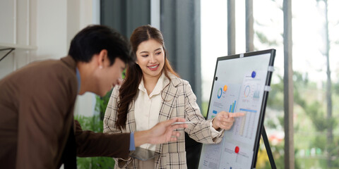 Data Presentation. Business professionals discussing analytics on a presentation board.