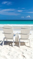 Two white beach chairs on a sandy shore (1)