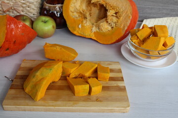 Mom cut up a pumpkin. Cubes of healthy seasonal vegetables lay on the table.