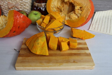 Mom cut up a pumpkin. Cubes of healthy seasonal vegetables lay on the table.